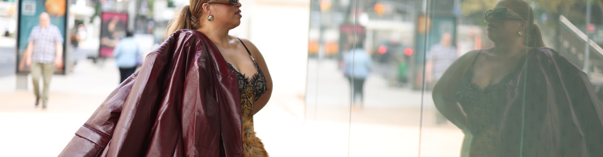 Suzanne Ujaque con chaqueta de cuero color vino frente a una vitrina en Nueva York
