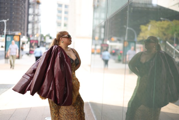 Suzanne Ujaque con chaqueta de cuero color vino frente a una vitrina en Nueva York